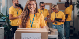 Portrait of a volunteer holding cardboard box with his colleague