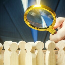 Businessman is studying a crowd of people with a magnifying glass. Hr search candidates for work, staff recruiting. Society, demographic. Market and customers research. Citizens electorate. Analysis