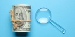 magnifying glass next to money