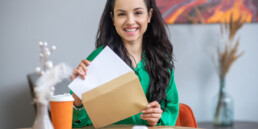 woman sitting at table opening mail