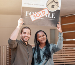 couple holding up sold sign