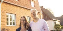 Couple in front of their home