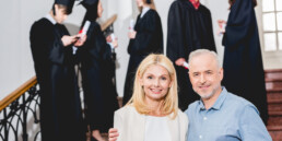 happy parents near group of graduating students