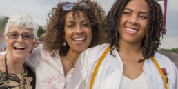 Teenage girl with mother and grandmother at graduation ceremony