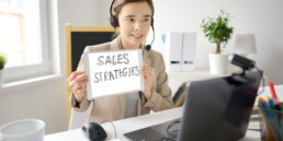 woman holding sign that says sales strategies