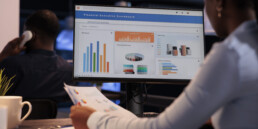 Office employee analyzing business charts on computer