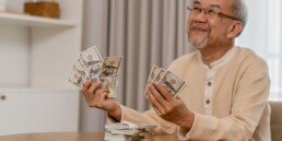 Senior holding money in both hands