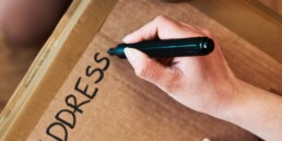 someone writing address on an envelope